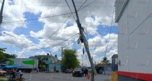 Camión de carga se atora en cables de luz y tira postes en Progreso