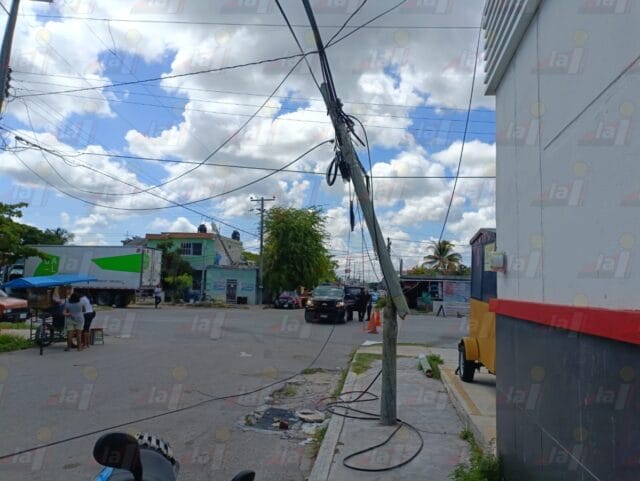 Camión de carga se atora en cables de luz y tira postes en Progreso